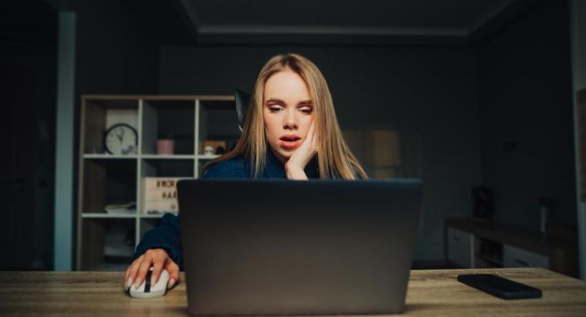 Woman looking shocked at laptop computer