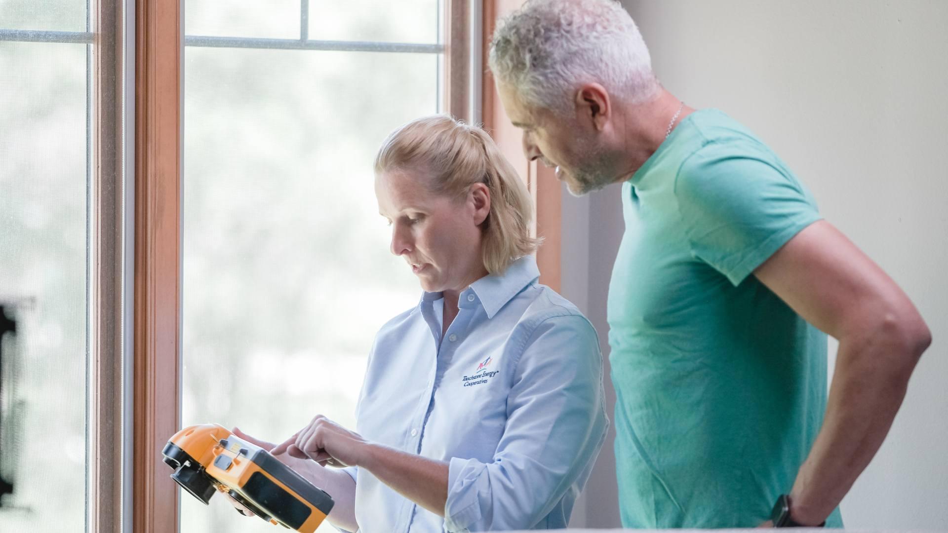 woman and man using tool to determine energy savings