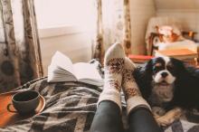 Cozy feet in fluffy socks by dog